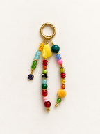 A colorful beaded keychain with a gold-tone split ring, featuring multiple strands of round and flat beads in yellow, green, red, pink, blue, and orange, with a small blue star charm.